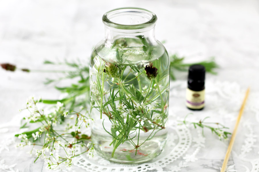 Horizontal photo of Botanical Herb Fragrance Diffuser with fresh lavender, lavender essential oil, and bamboo skewer also in photo.