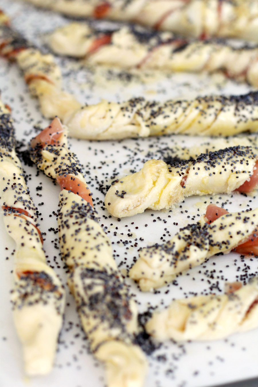 Puff pastry dough twisted into wands and sprinkled with poppy seeds.