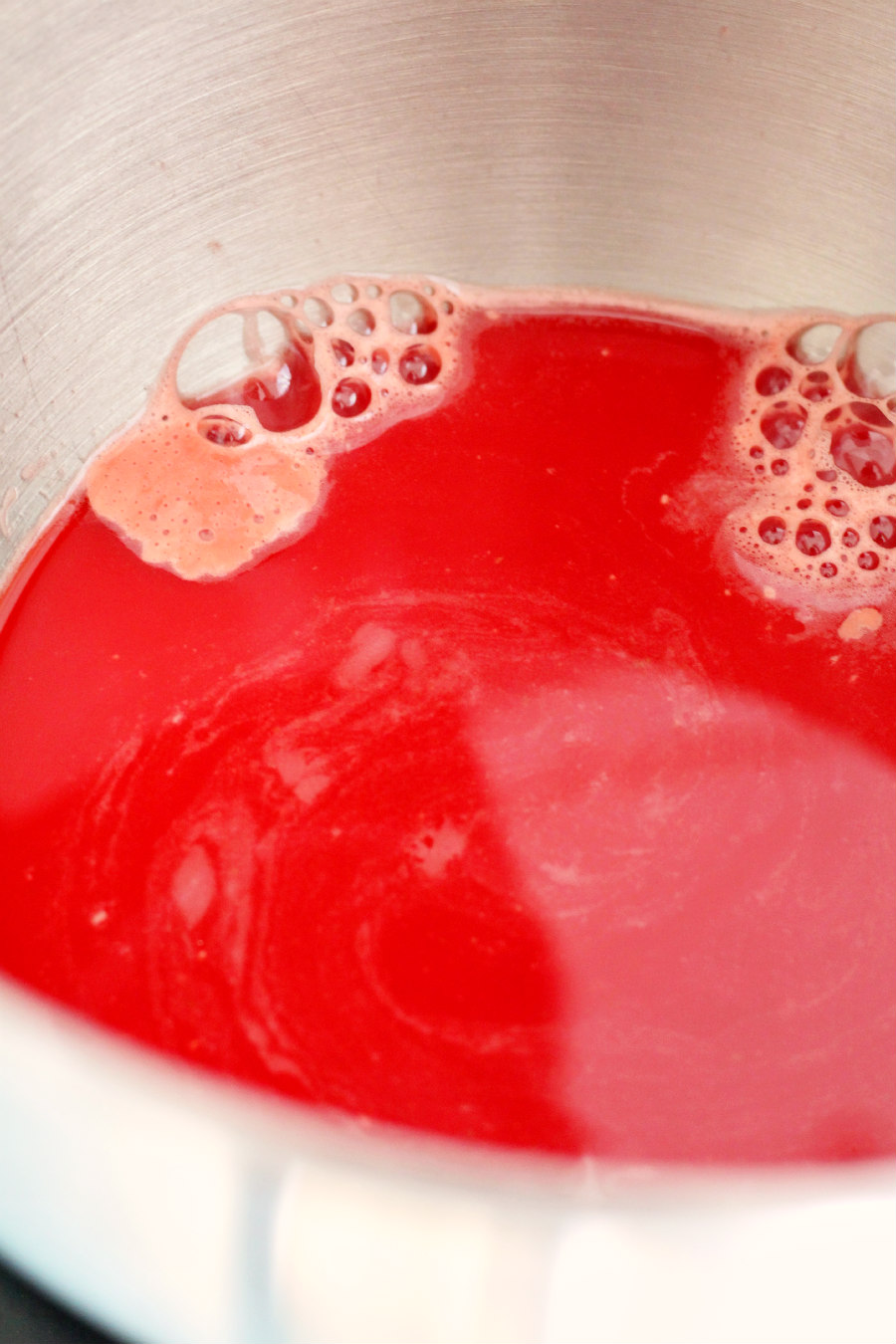 Beet juice, honey, and yeast in a metal mixing bowl.